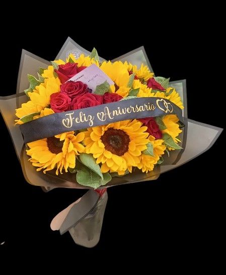 Bouchon de rosas y girasoles con cinta Feliz Aniversario